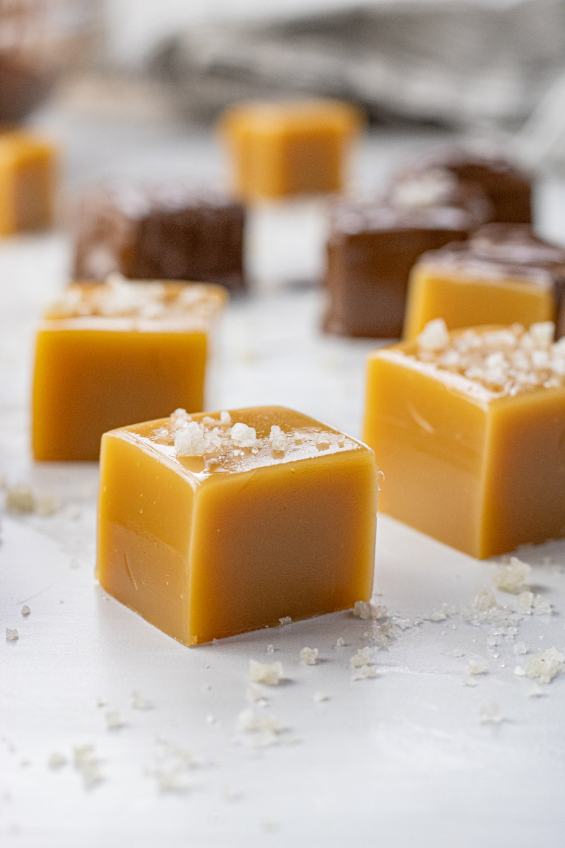 close up of square of caramel topped with sea salt