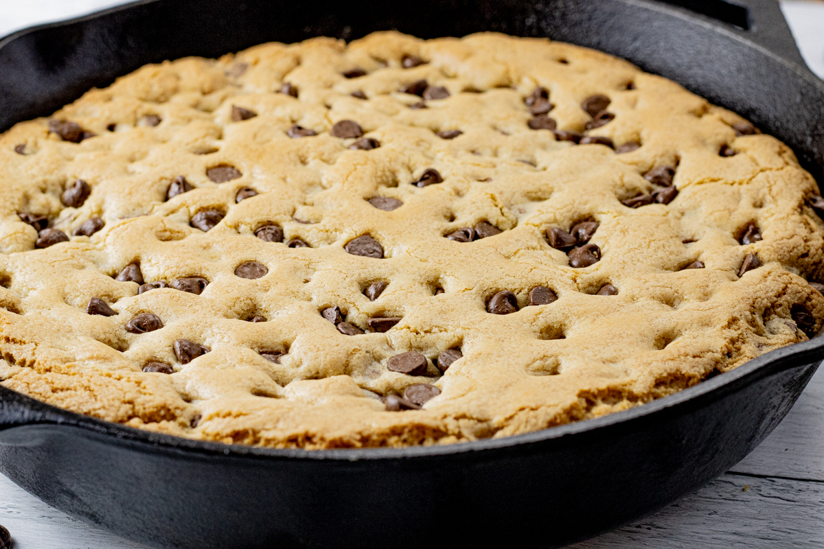 close up of giant chocolate chip cookie in a cast iron skillet