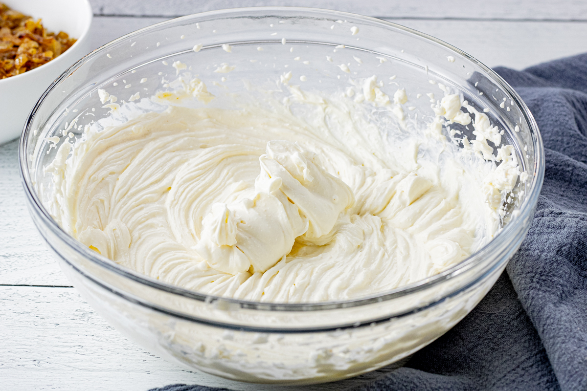 glass mixing bowl with smooth, beaten cream cheese
