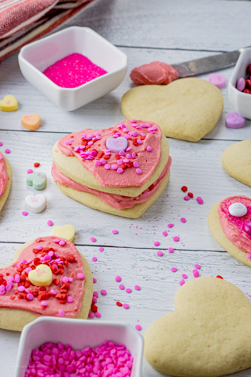 heart shaped cookies topped with pink frosting and valentine's candies