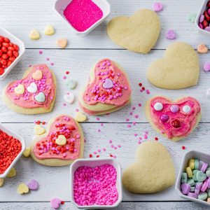 heart shaped sugar cookies topped with pink frosting and candies