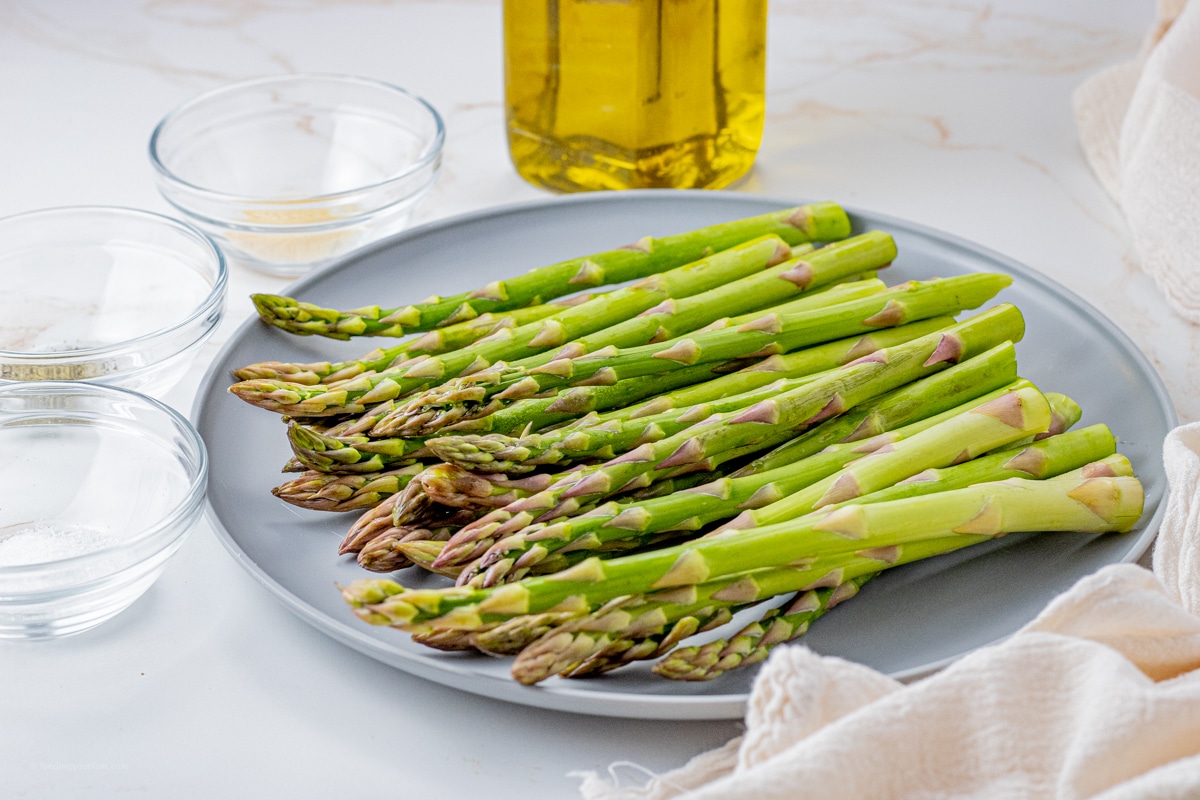 green asparagus on a grey round plate