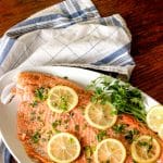 cooked salmon topped with lemon slices and parsley