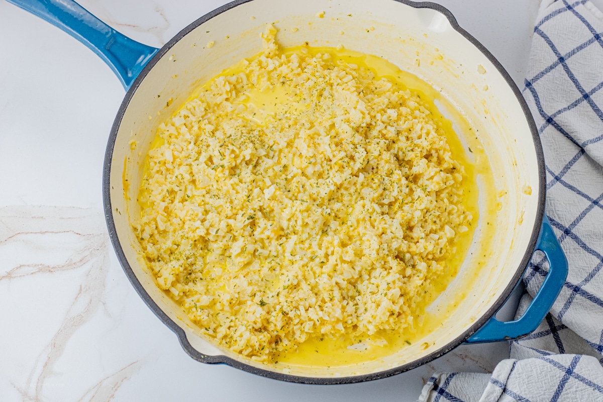cauliflower rice in a cheesy sauce in a large skillet