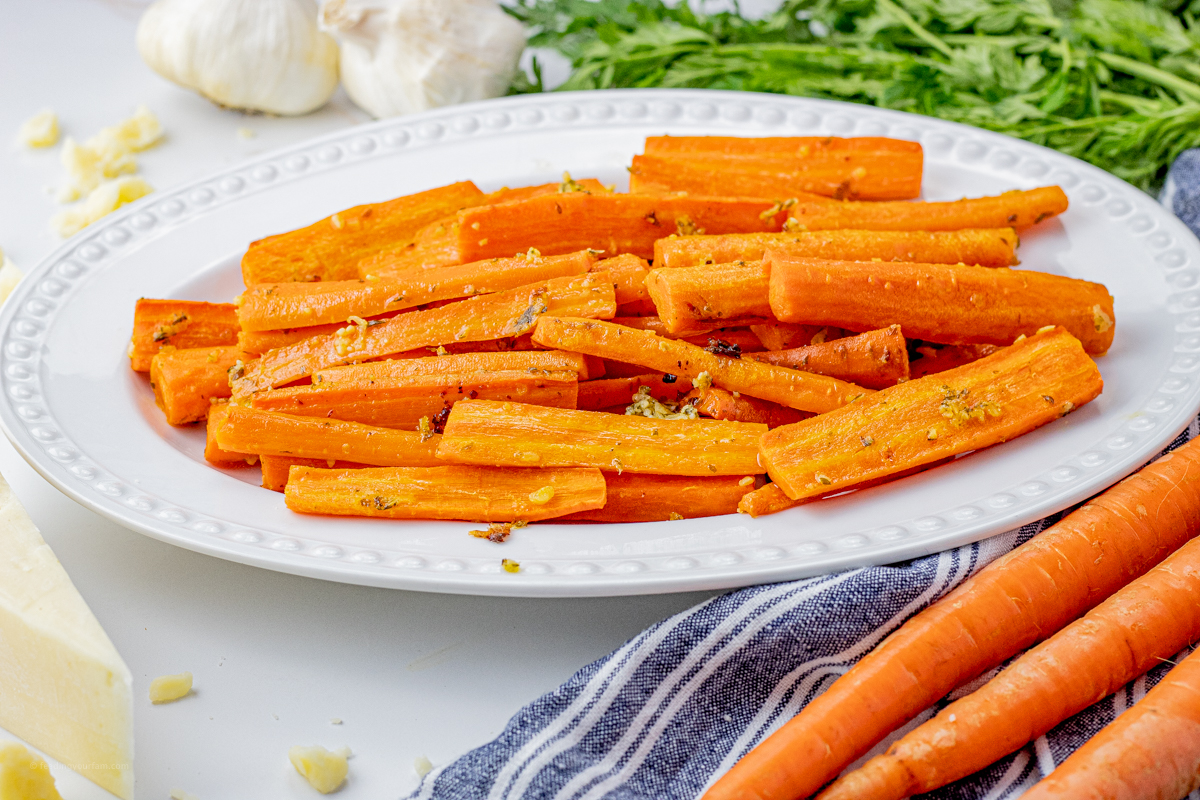 sliced, orange carrots on a white serving platter