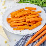cooked carrots on a white serving platter