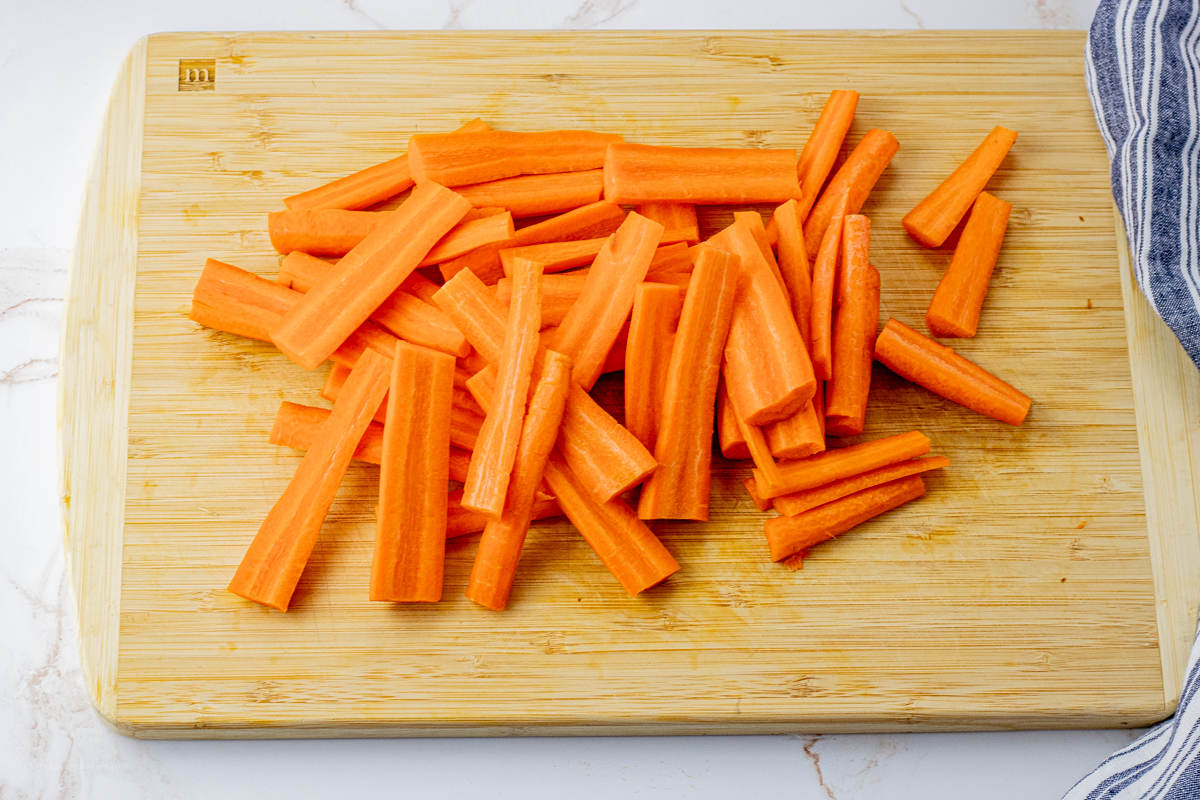 sliced, orange carrots on a wooden cutting board