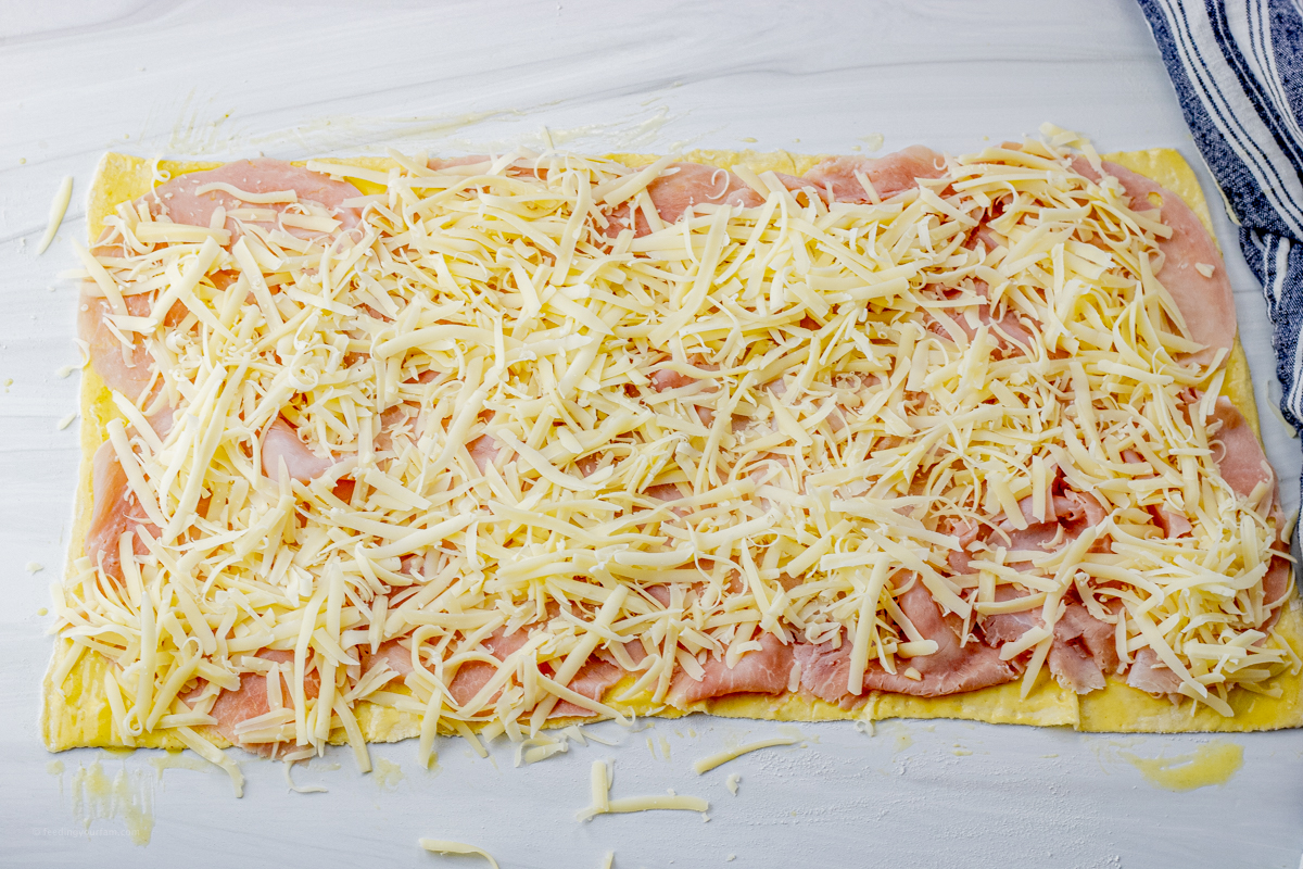 puff pastry sheet topped with ham and grated swiss cheese
