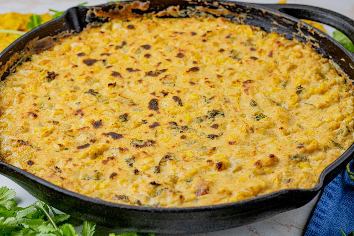 black cast iron pan filled with a cheesy corn dip