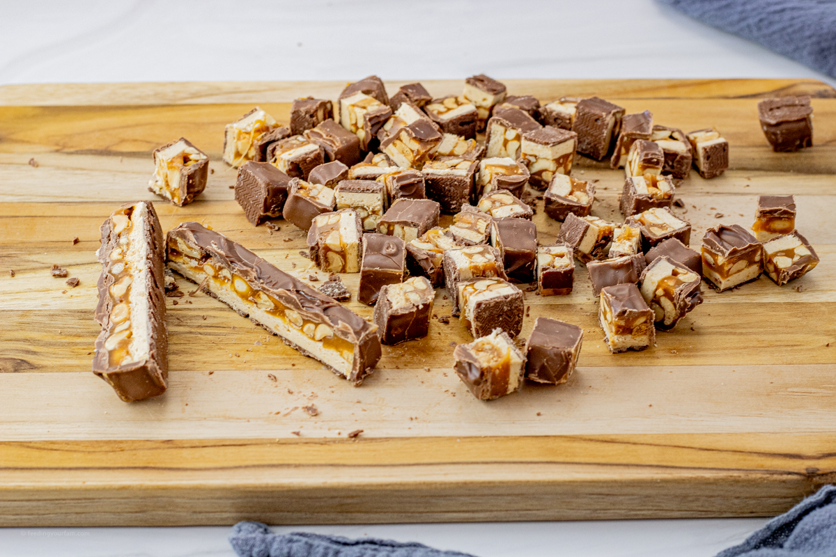 chopped snickers bar on a wooden cutting board