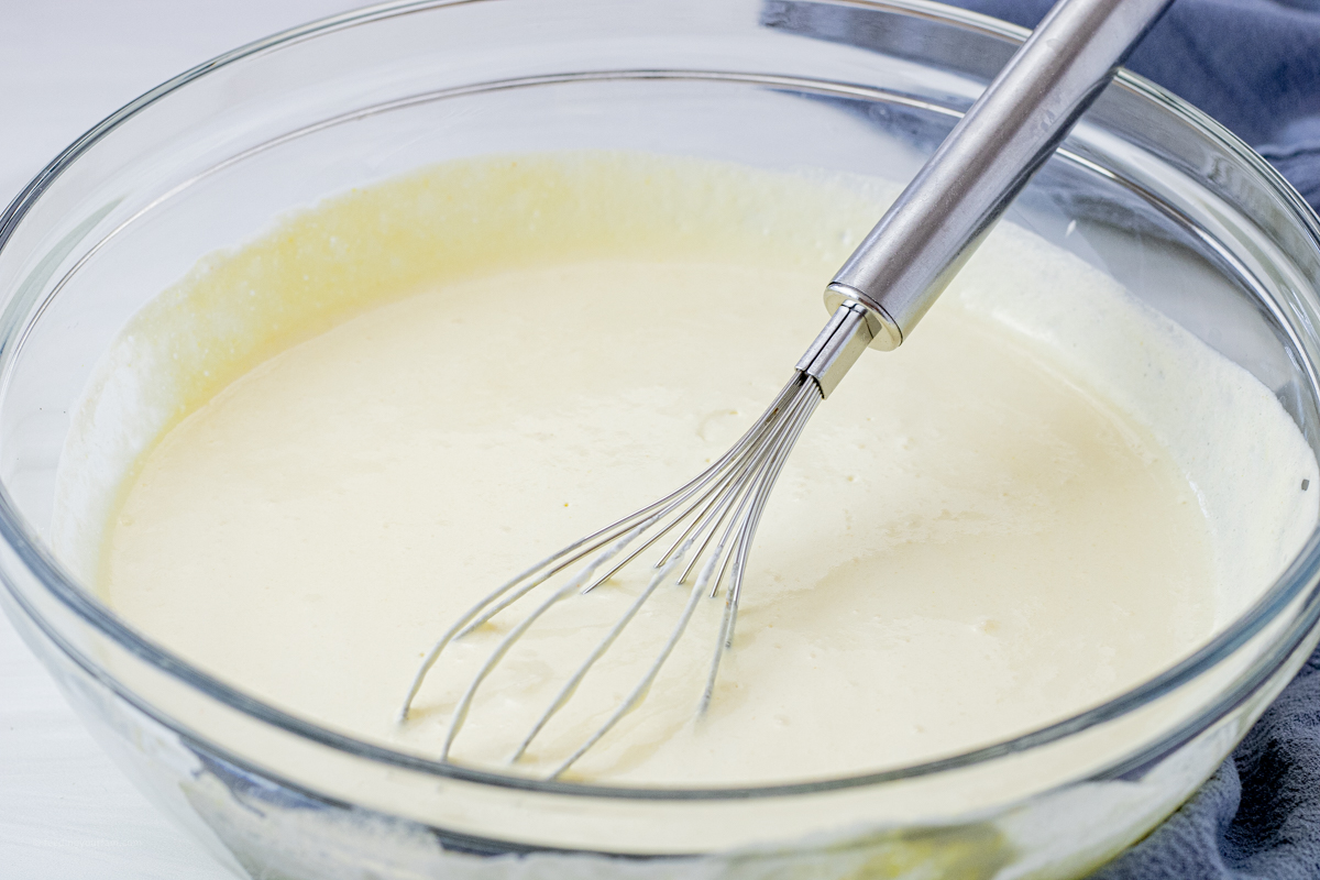 vanilla pudding in a glass mixing bowl with a metal whisk