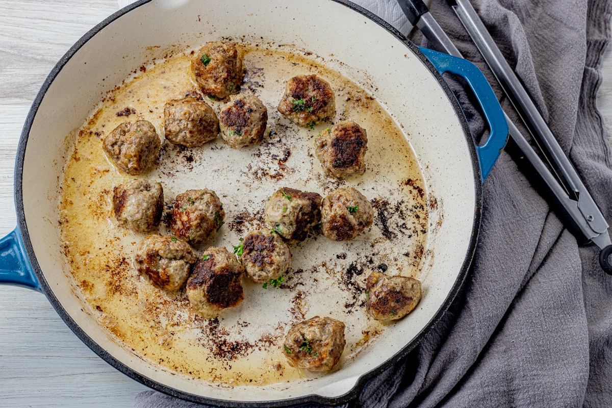 cooked meatballs in an enameled cast iron pan