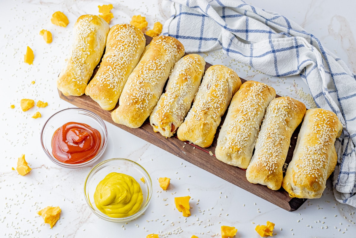cooked hot dogs wrapped in biscuit dough topped with sesame seeds