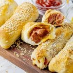 hot dog wrapped in biscuit dough broken in half with cheese inside