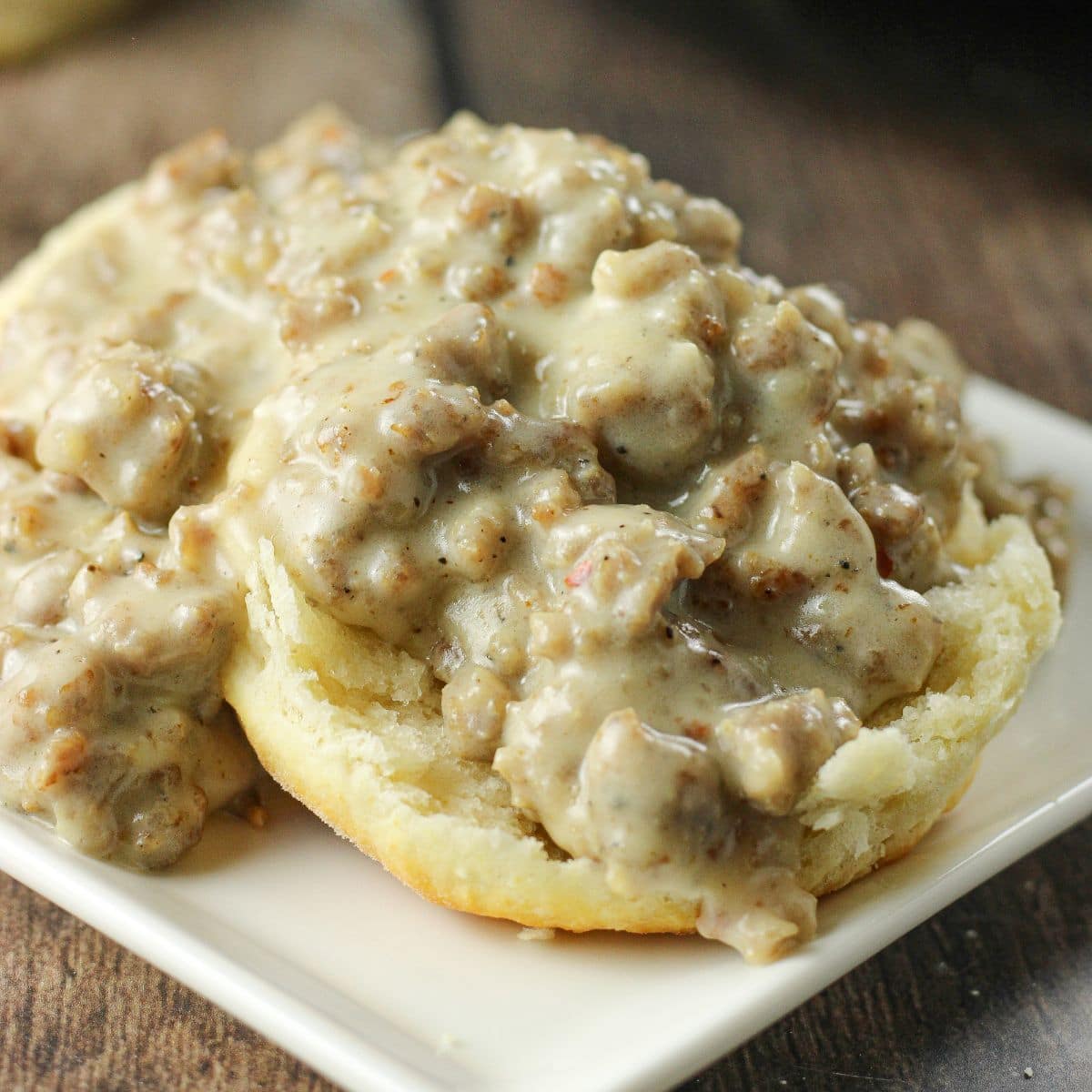 biscuits topped with sausage gravy on a white plate
