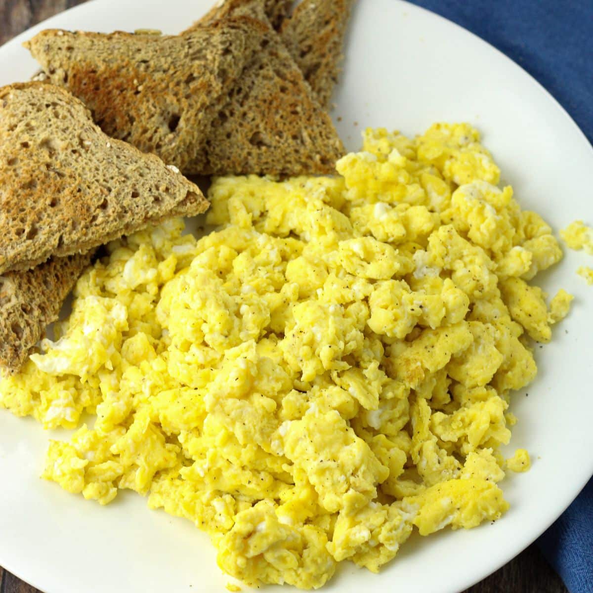 scrambled eggs and toast on a white plate