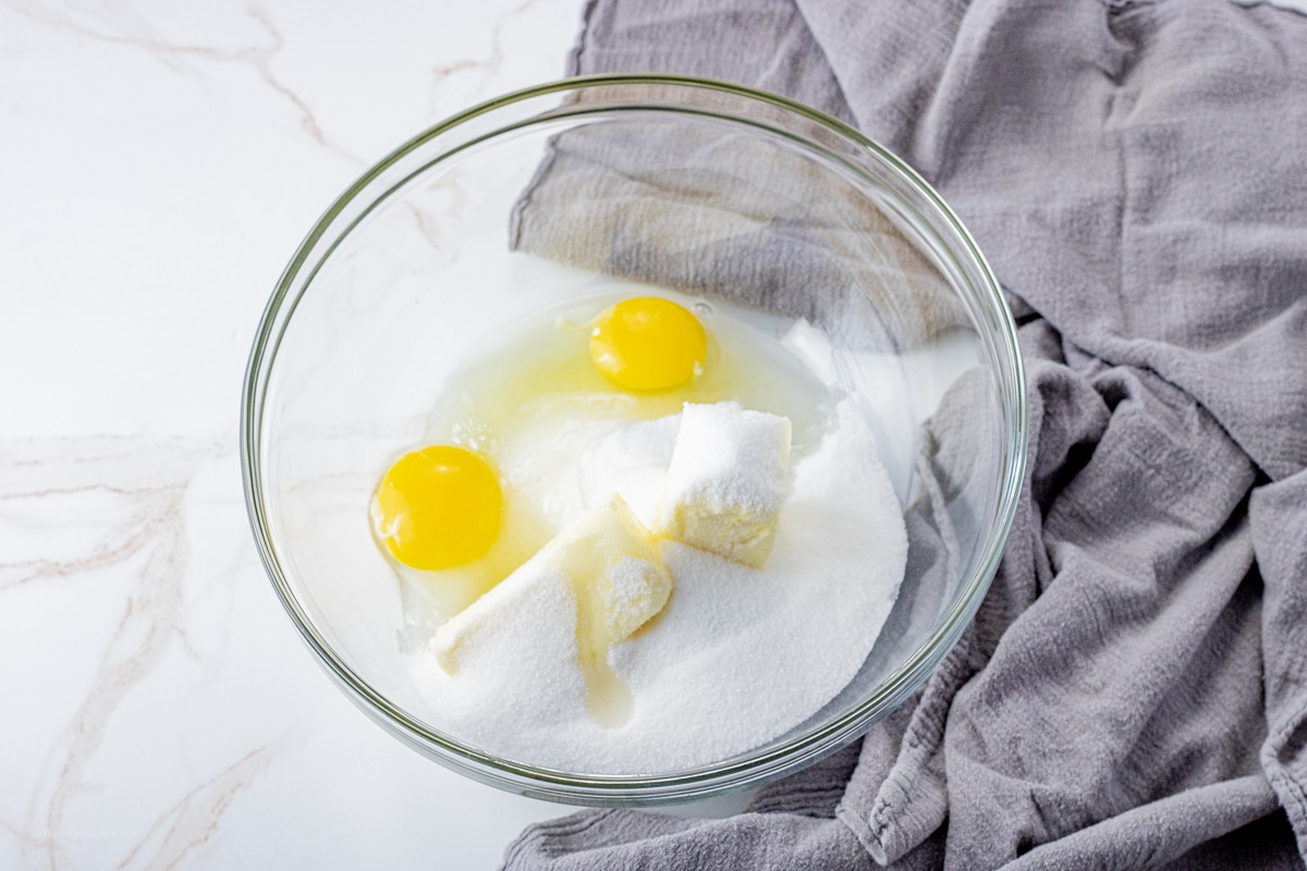 butter, sugar and eggs in a glass mixing bowl