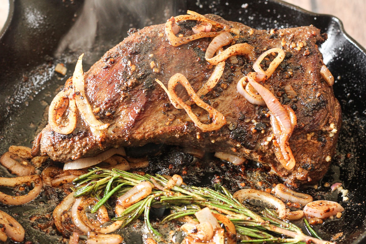 cast iron cooked tri tip beef roast with shallots and rosemary