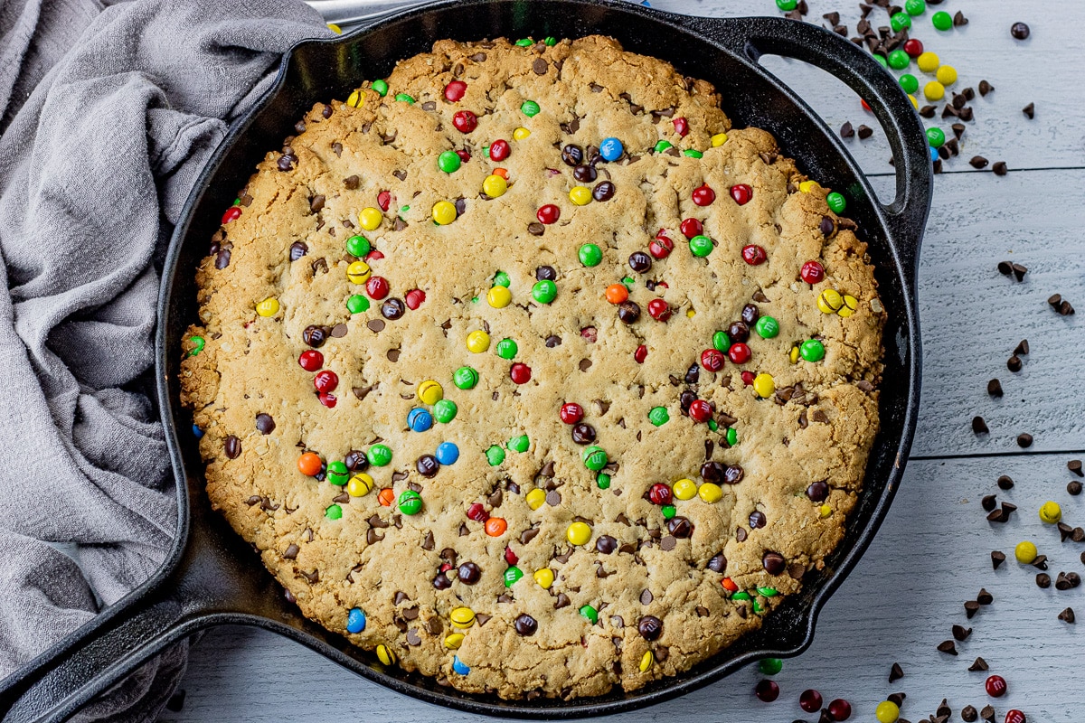 cast iron skillet chocolate chip cookie with colorful chocolate covered candies