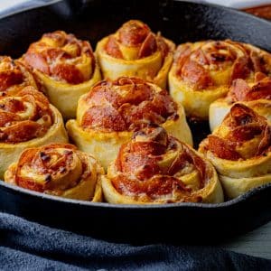 cooked pepperoni pizza rolls in a cast iron pan