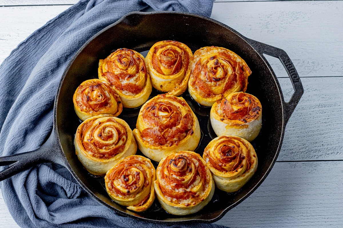 cooked pepperoni pizza rolls in a cast iron pan