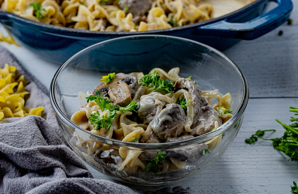 beef stroganoff with egg noodles in a glass bowl