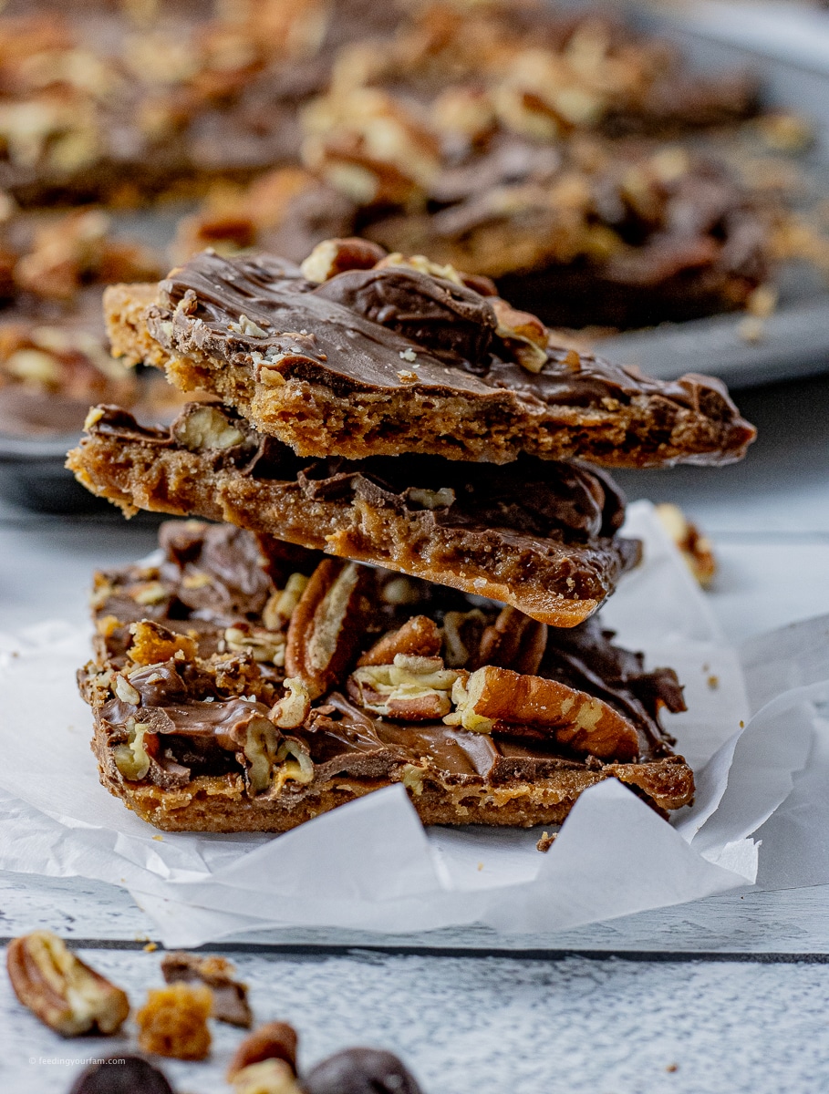 stack of graham crackers in a butter toffee topped with chocolate and pecans