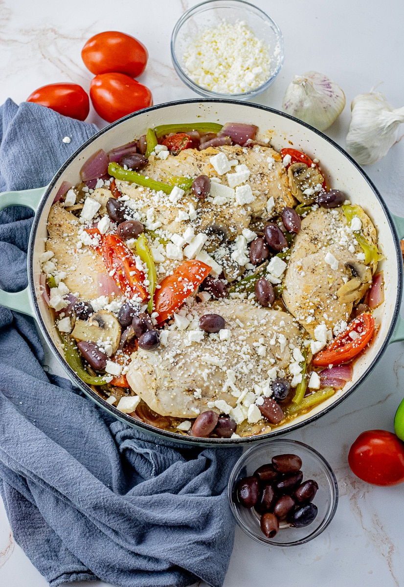 big cast iron pan with chicken, tomatoes, green peppers, mushrooms, kalamata olives and feta cheese