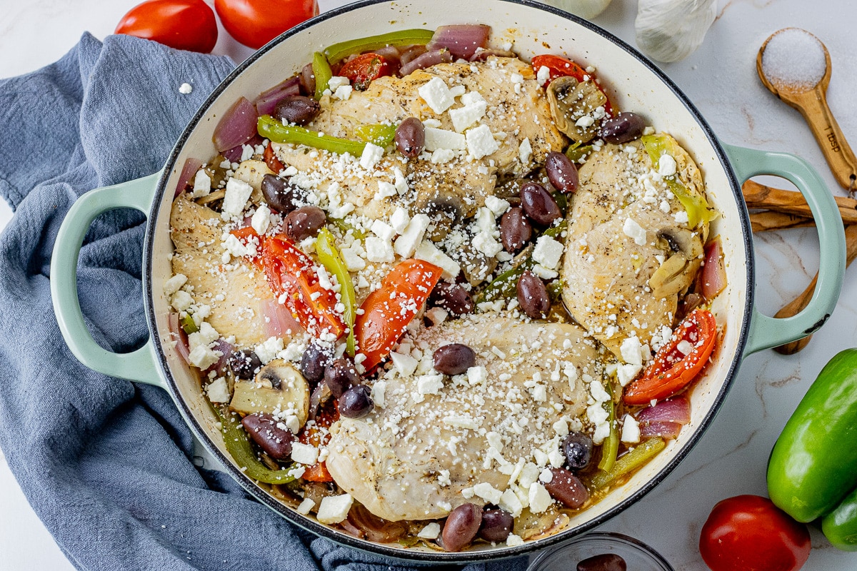 4 chicken breasts in a cast iron pan with tomatoes, mushrooms, green peppers, red onions, kalamata olives and feta cheese