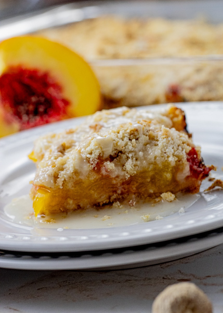 These Peach Crumb Bars feature fresh peaches, with a delicious shortbread like crust and simple spices to enhance the flavors. Peach crumb bars are a perfect fresh peach dessert recipe that are perfect for a simple recipe, but make enough to share with the whole fam and then some.