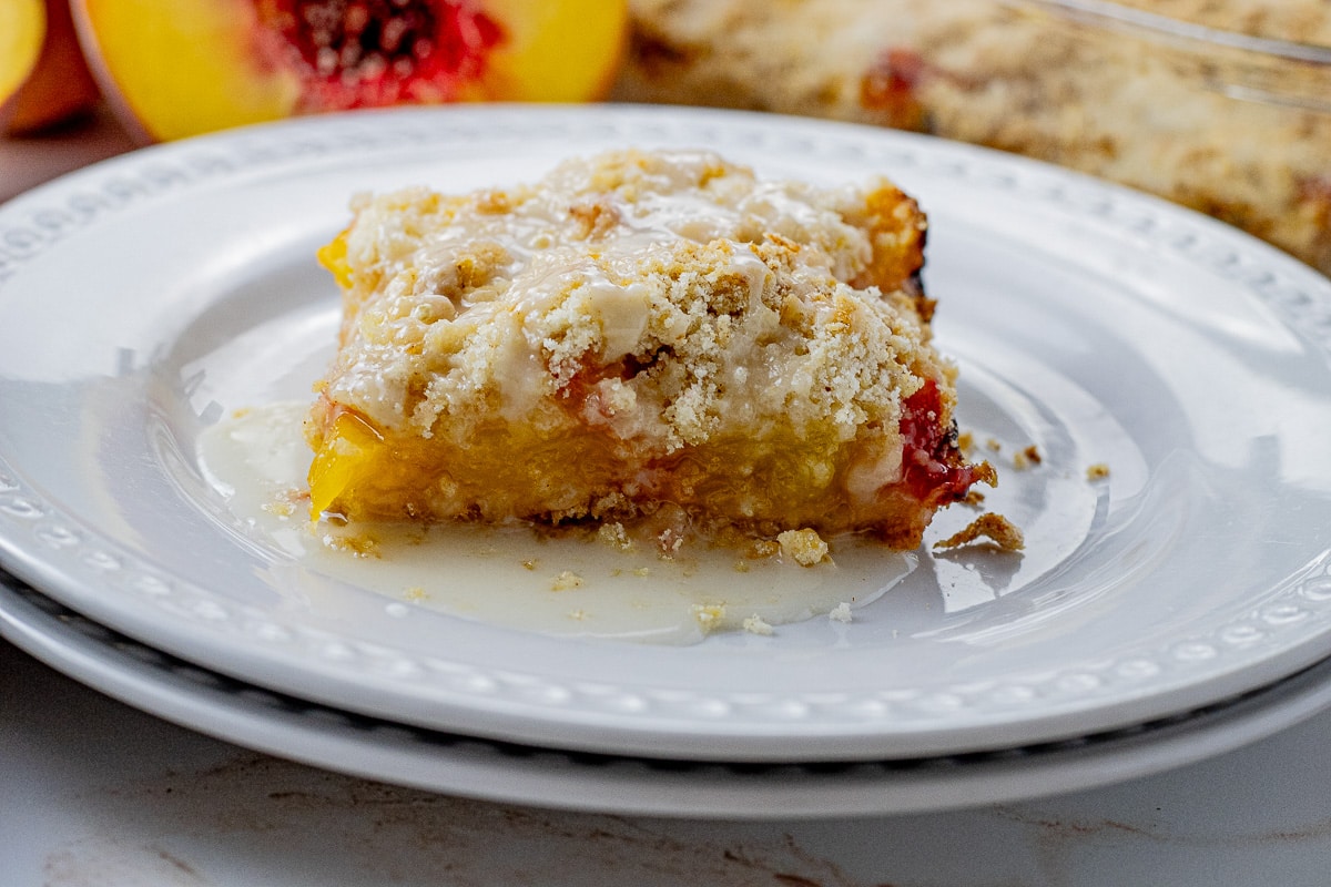 square of peach crumb bar on a white plate 