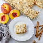 peach crumble bars with a square on a white plate
