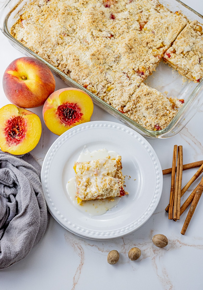 crumb bars made with peaches, a small square on a plate with a simple glaze