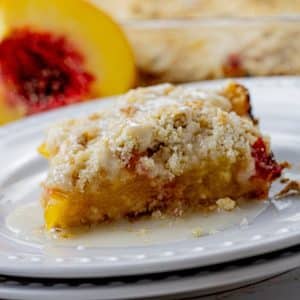 square of peach crumb bar on a white plate
