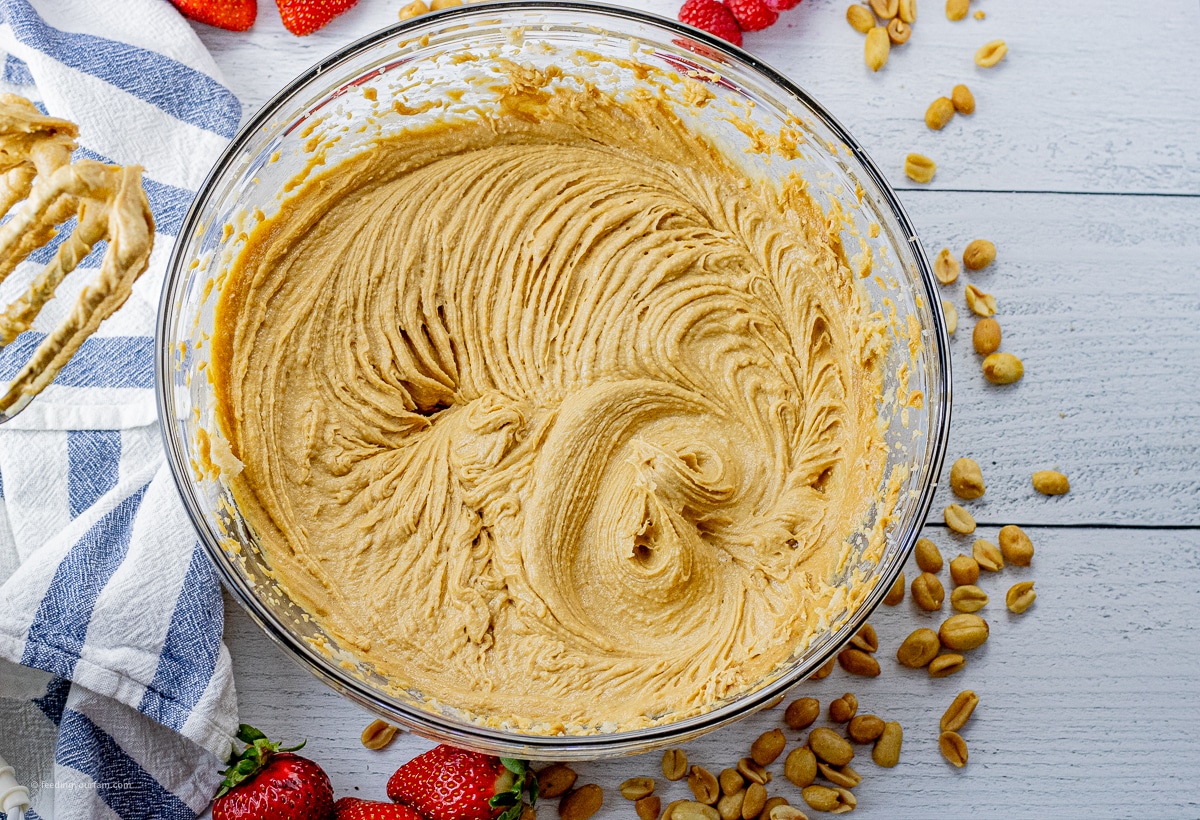 peanut butter, sugars, butter, baking powder and vanilla mixed in a glass mixing bowl