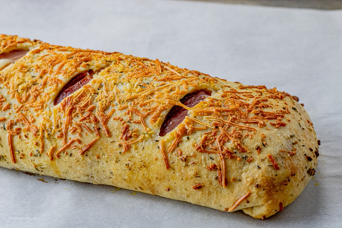 golden brown stromboli on a baking sheet topped with parchment paper
