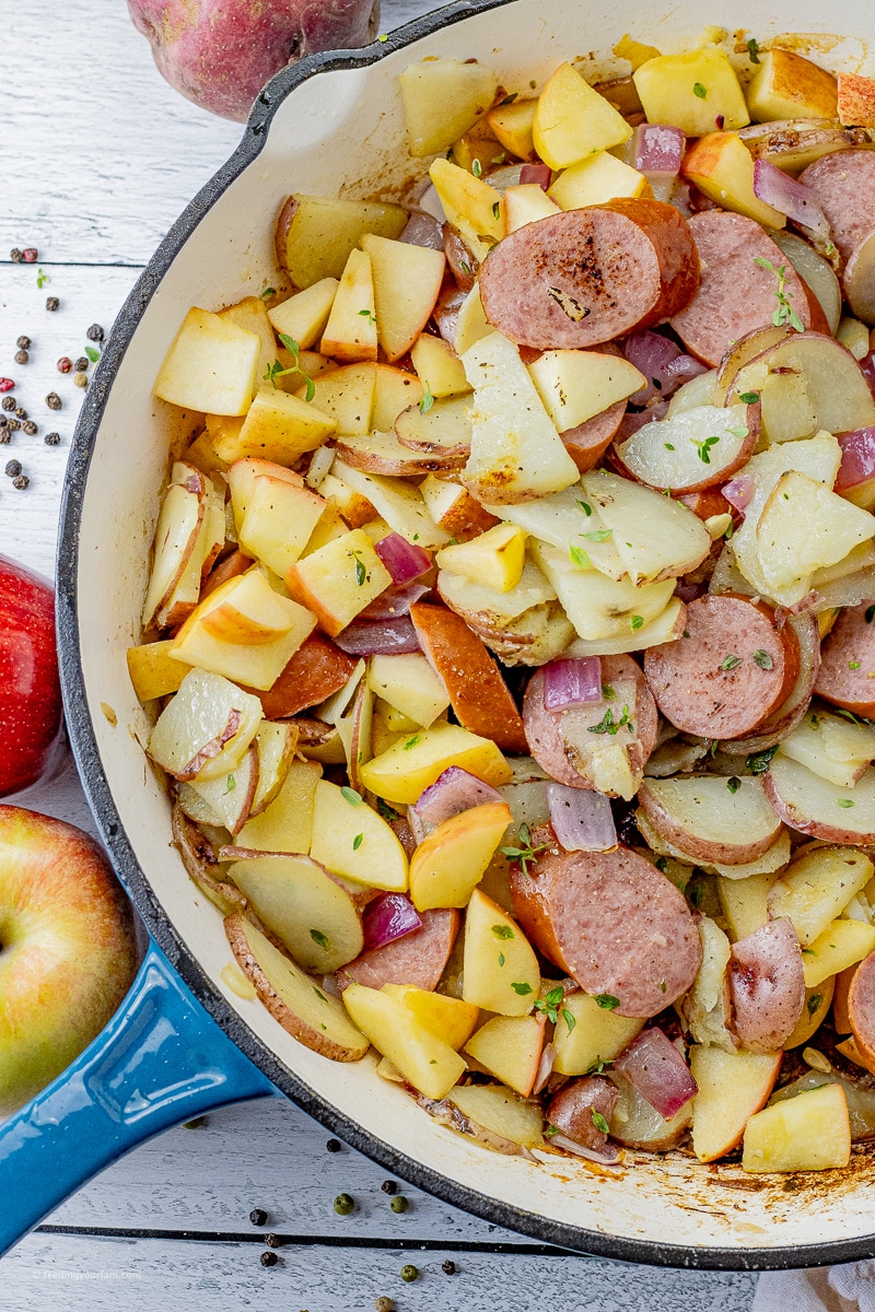big pan of sliced turkey sausage with potatoes and apples