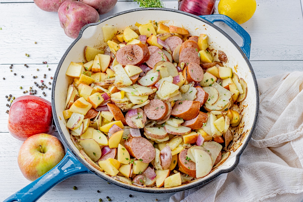 big pan of sliced turkey sausage with sliced potatoes and apples