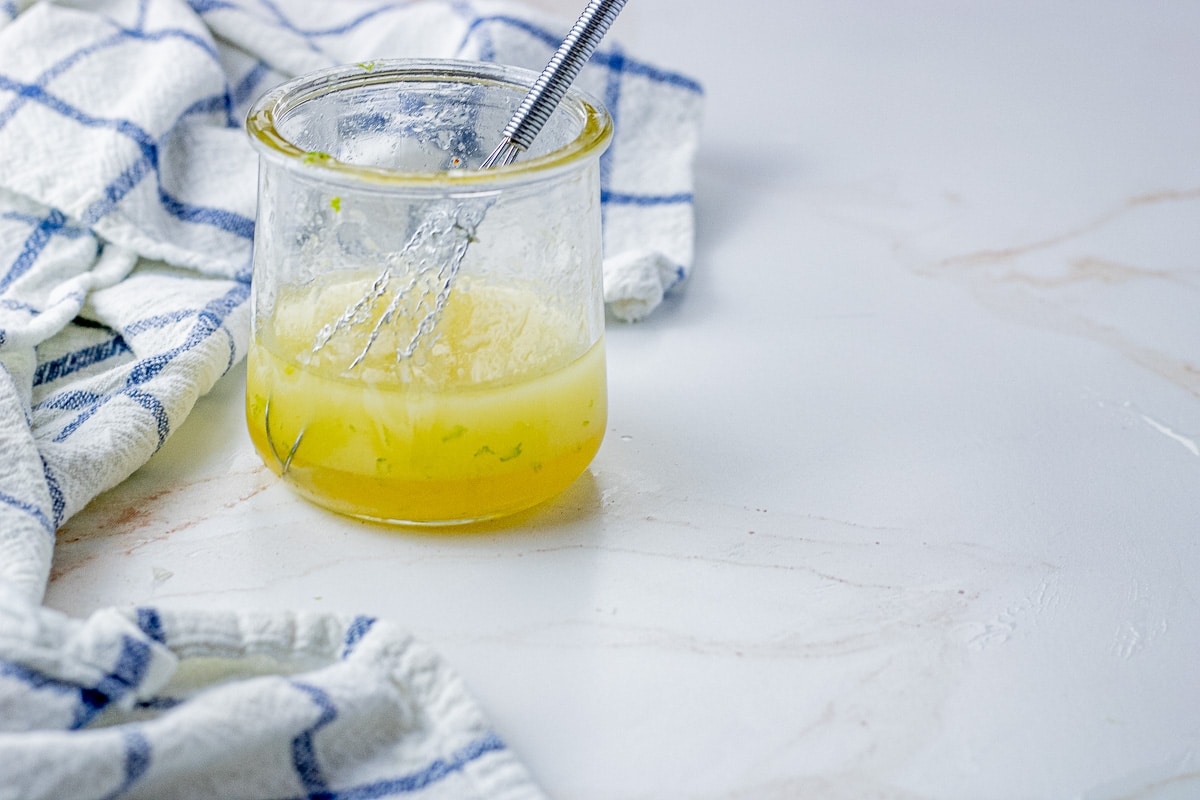 small glass jar of honey lime dressing