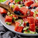 spoon scooping up some watermelon with feta and blueberries