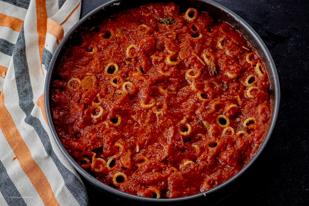 rigatoni cooked, then standing in a round springform pan topped with spaghetti sauce