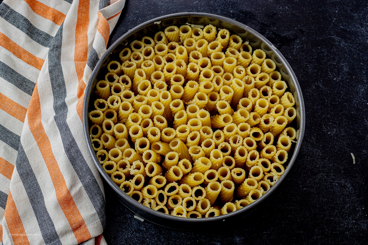 rigatoni standing up in a round springform pan