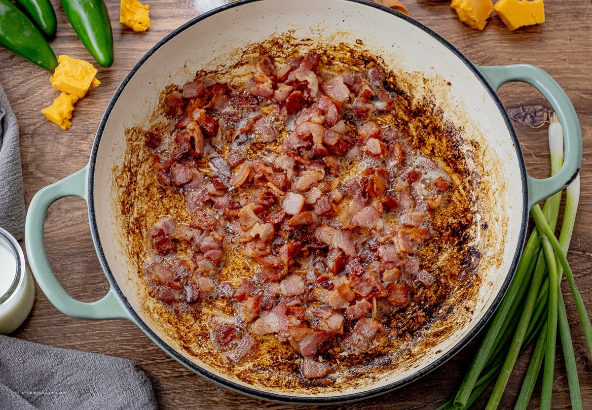 cooked chopped up pieces of bacon in a large round pan