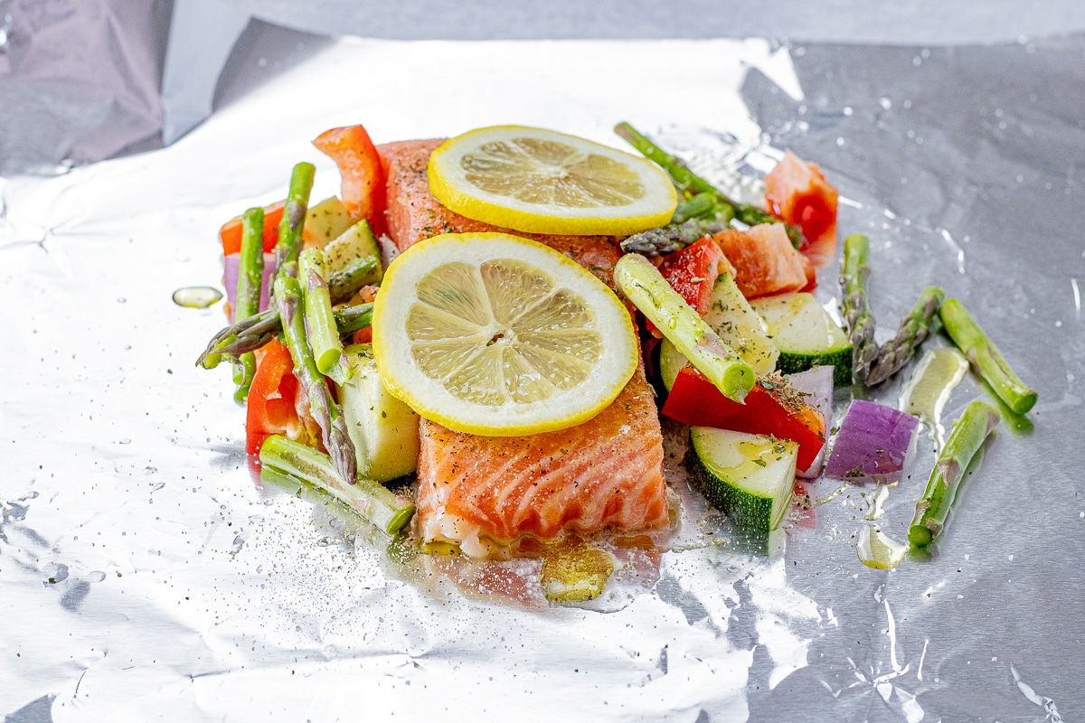 uncooked salmon with vegetables on a sheet of foil