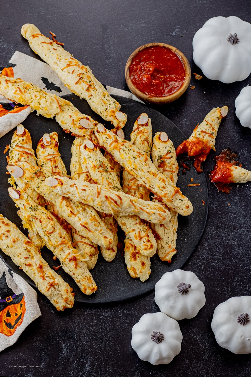 These cheesy garlic breadsticks come to life with a little extra crispy cheese on the outside, some tomato paste and a slivered almond. It is so easy to make these garlic biscuits into a creepy, but oh so delicious, witches fingers breadsticks.
