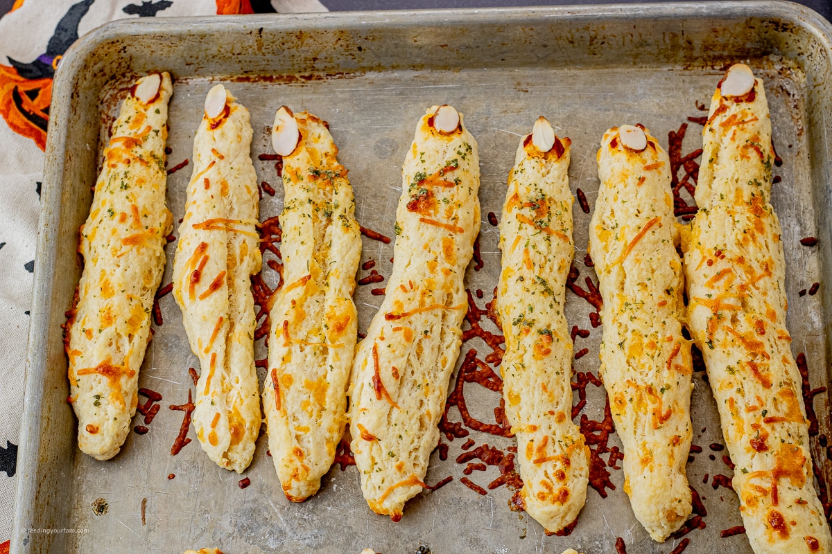 cheesy biscuits made into witch fingers baked on a baking sheet