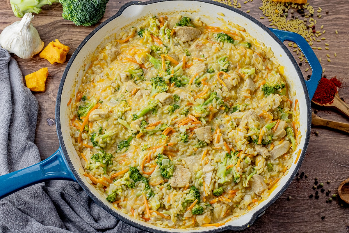 cheesy orzo with chicken, broccoli and carrots in a large skillet