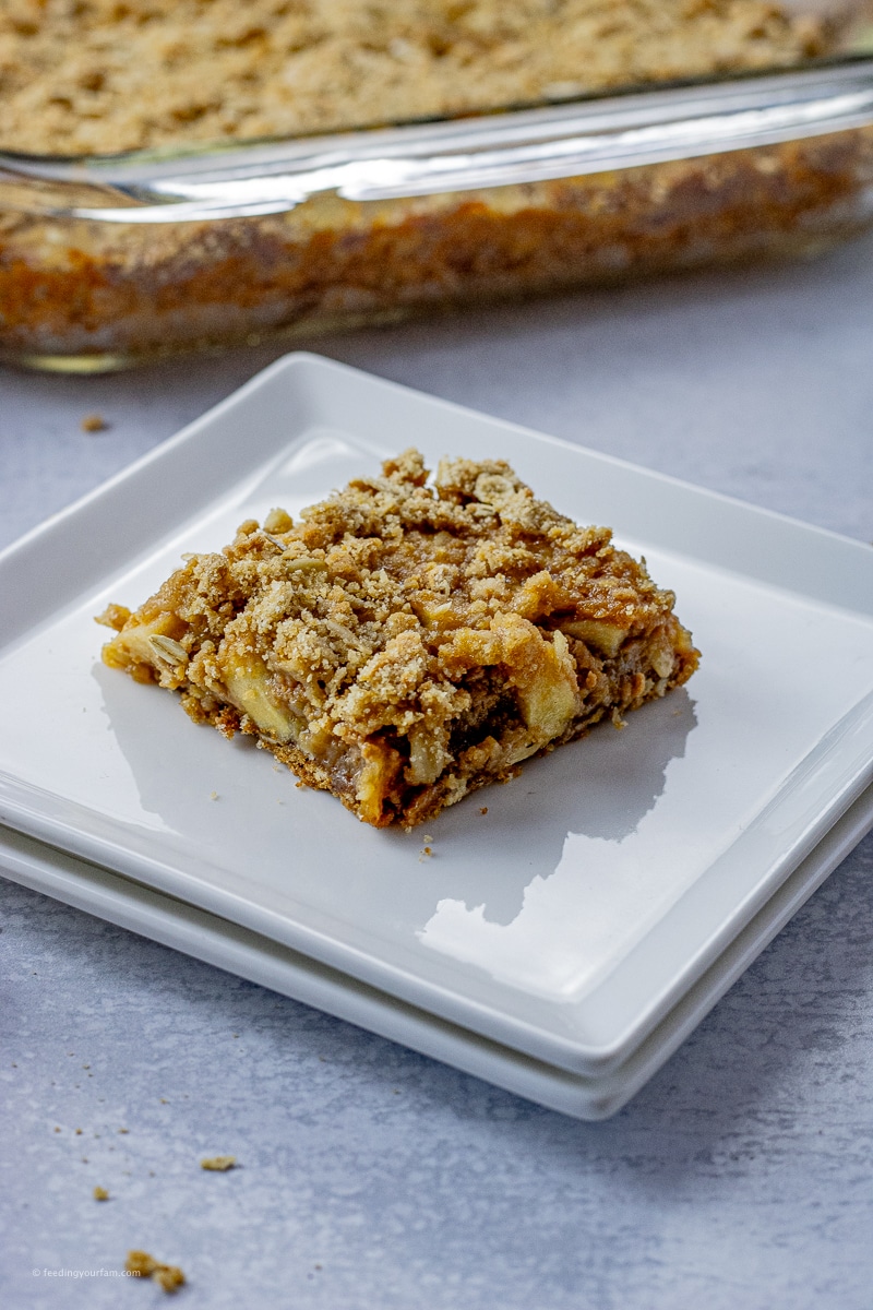 slice of square made from buttery oat crust with apples and caramels