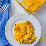 white plate with cheesy corn casserole on it