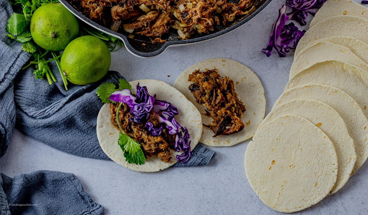 pulled pork tacos topped with red cabbage and cilantro